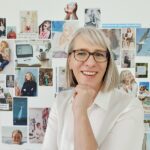Frau mit Brille vor Wand mit Bildern